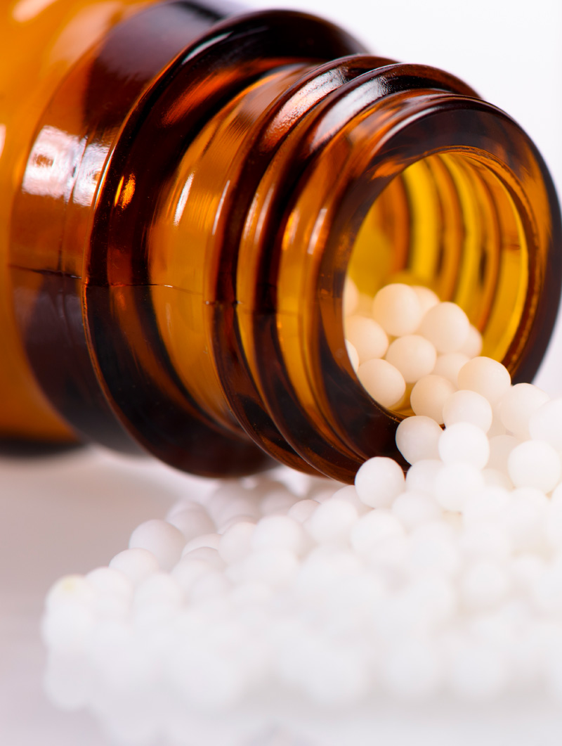 Globuli vor braunem Glasflacon