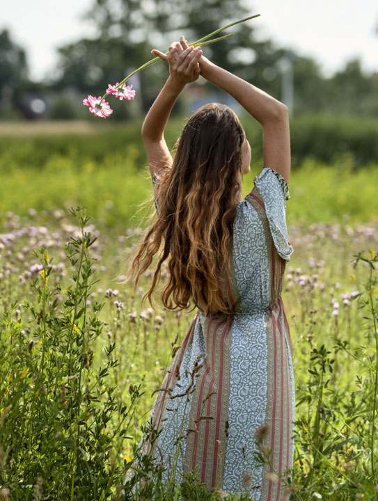 Frau von hinten auf einer blühenden Wiese